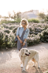 Close-up portrait of rich man playing outdoor with her dog on the street,dog licks his master,girl hugging her puppy,golden labrador puppy,funny mood,positive emotions,kissing lips,walking alone,urban