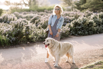 Close-up portrait of rich man playing outdoor with her dog on the street,dog licks his master,girl hugging her puppy,golden labrador puppy,funny mood,positive emotions,kissing lips,walking alone,urban