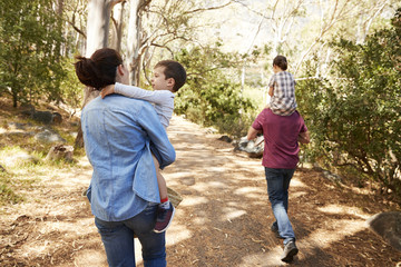 Children Riding On Parent's Shoulders On Countryside Walk