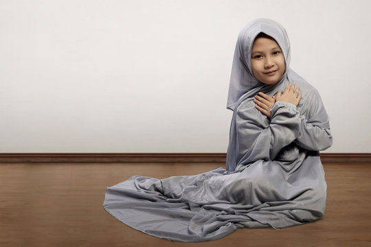Little asian muslim kid wearing veil praying