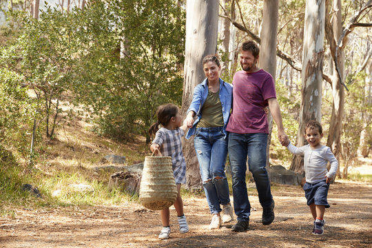 Family Walking Along Path Through Forest Together