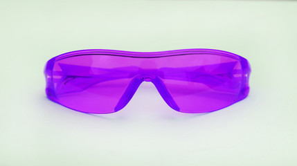 Fototapeta premium Purple safety glasses on white background.