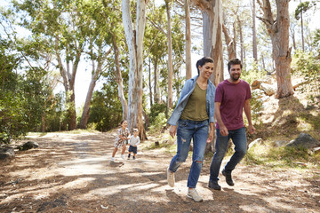 Family Running Along Path Through Forest Together