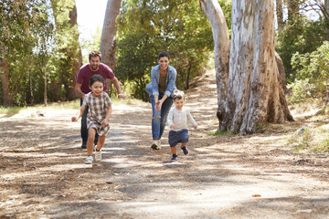 Family Running Along Path Through Forest Together
