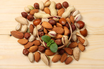mix almonds, cashew nuts, hazelnut, peanuts, walnuts, pistachio in wood plate on wood background