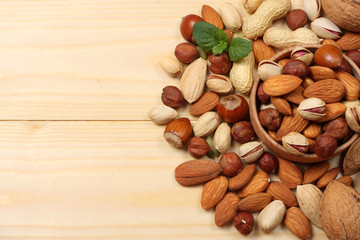 mix almonds, cashew nuts, hazelnut, peanuts, walnuts, pistachio in wood plate on wood background
