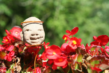 statuina azteca tra i fiori rossi