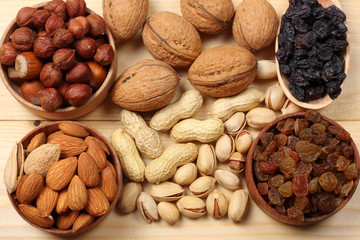 mix almonds, cashew nuts, hazelnut, peanuts, walnuts, pistachio in wood plate on wood background