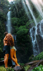Fototapeta na wymiar Couple and a waterfall in Bali