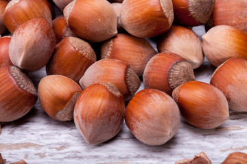 Brown Hazelnuts on white wooden background in studio photo. Healhty snacks