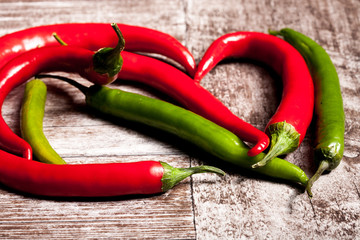 Green and red spicy papper on wooden background in studio photo. Fresh organic food