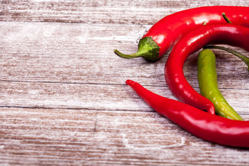 Green and red spicy papper on wooden background in studio photo. Fresh organic food