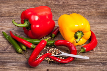 Sweet and spicy peppers on wooden background in studio photo. Raw healthy food