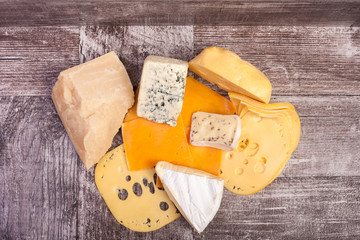 Over top view of different type of cheese on wooden background. Healthy food. Snacks and products
