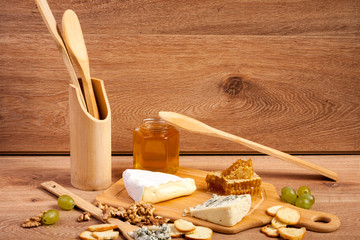 Fototapeta na wymiar Cheese, nuts and honey on wooden background. Healthy food. Snacks and products
