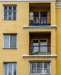 Fototapeta premium Three big balconies on yellow wall with windows