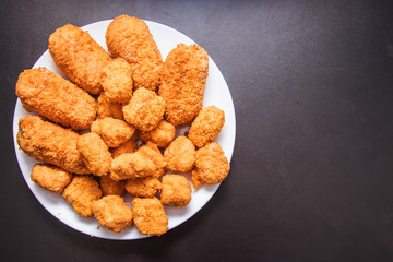 Cutlets in breading on a black background