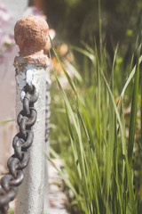 Elements of a metal fence with chains. Closeup, selective focus.