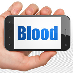 Medicine concept: Hand Holding Smartphone with Blood on display