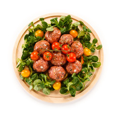 Raw meatballs on cutting board on white background