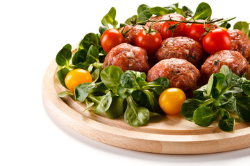 Raw meatballs on cutting board on white background