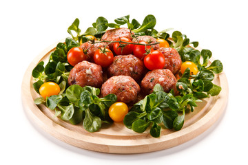 Raw meatballs on cutting board on white background