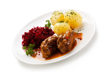 Wrapped pork chops with potatoes and beetroots on white background