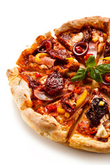 Pizza with ham, corn, mushrooms and dried tomatoes on white background