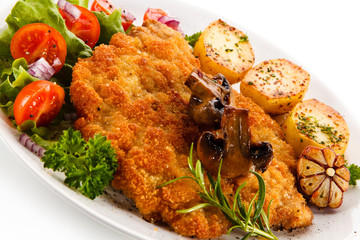Fried pork chop with potatoes on white background