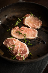 Raw ribeye beef steak with rosemary on pan. Top view. Restaurant