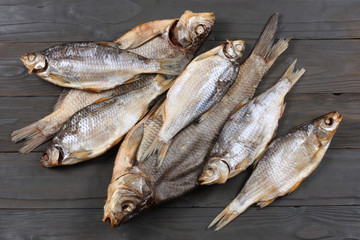 Dried fish on the table. Salty dry river fish on a dark wooden background.top view