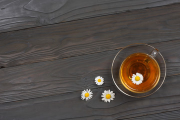 cup of green tea with chamomile on old wooden table. top view with copy space