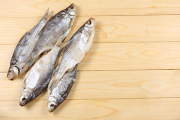 Dried fish on the table. Salty dry river fish on a light wooden background.top view with copy space