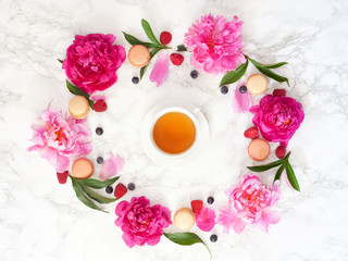 Tea time. Flat lay over light background with peonies  and cup of tea