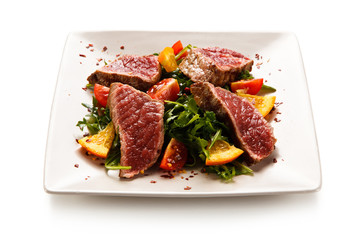 Fillet mignon - grilled beefsteaks with vegetables on white background