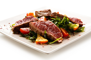 Fillet mignon - grilled beefsteaks with vegetables on white background