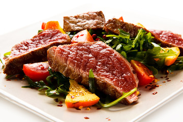 Fillet mignon - grilled beefsteaks with vegetables on white background