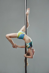 Junior acrobat on pylon at pole dance studio