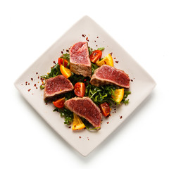 Fillet mignon - grilled beefsteaks with vegetables on white background