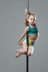 Junior acrobat on pylon at pole dance studio