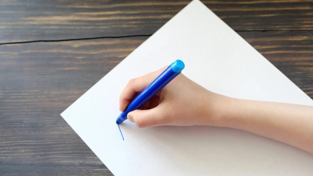 Child's hand writing letters, closeup shot