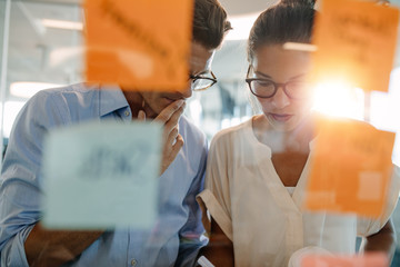 Business professionals standing behind the glass wall with stick