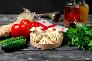 Khinkali on a wooden table with vegetables
