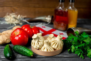 Khinkali on a wooden table with vegetables