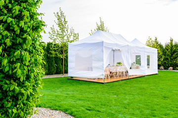 Party tent - white garden party or wedding entertainment tent in modern garden - obrazy, fototapety, plakaty