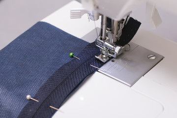 Work on a sewing machine with a zipper foot