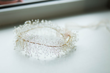 round lush beautiful wedding hair accessory is handmade from transparent crystals, Golden beads on a wire, on a white background close-up