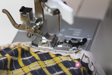Work on a sewing machine with an overlock foot, joining a rubber band with a zigzag stitch