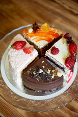 The different pieces of the cake smoothly rotate on the base.There is chocolate, carrot, yogurt and berries.