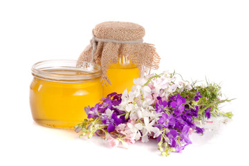 Obraz na płótnie Canvas Jar of honey with wildflowers isolated on white background